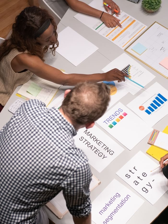 About Team discussing marketing strategies in a modern office setting with charts and documents.